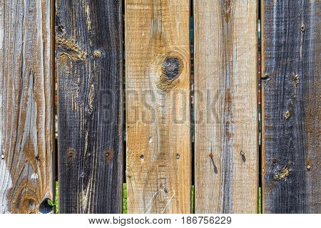 Horizontal weathered, multi-colored wooden fence background with 5 boards