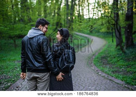 man tocuhs womans ass while walking in city park