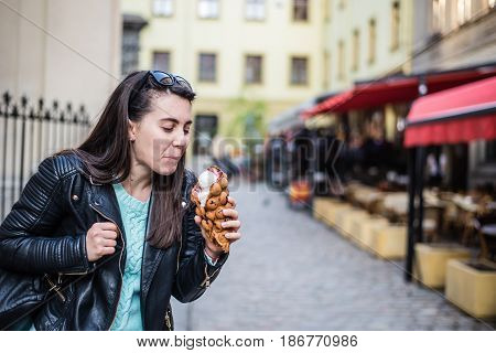 woman eat icecream oustide wile walking the city