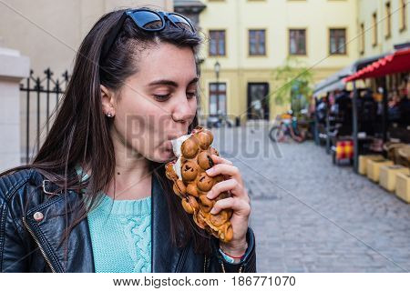 woman eat icecream oustide wile walking the city