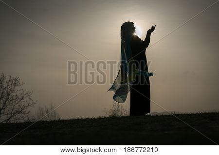 Woman with her hands up on sunset