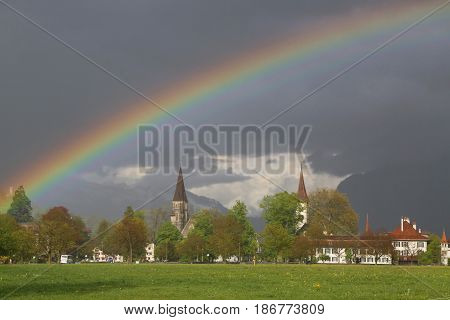 INTERLAKEN, SWITZERLAND - MAY 4, 2017: Rainbow over city of Interlaken, Switzerland