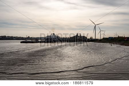 Dusk view over the ferry terminal of the Port of Tilbury on the Essex coast of England with a passenger ship in berth.