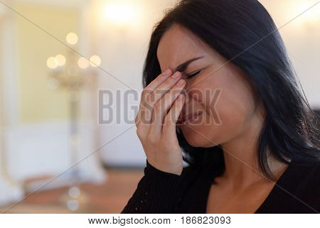 burial, people and mourning concept - close up of crying unhappy woman at funeral in church