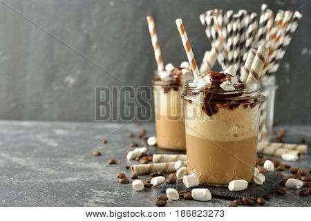Cold frappe coffee with cream on a gray background