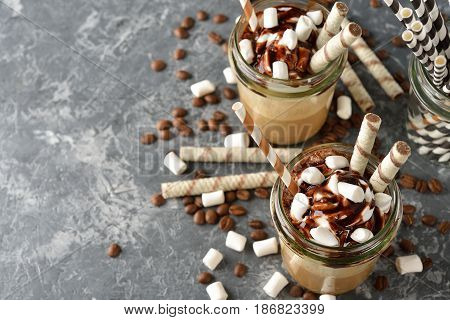 Cold frappe coffee with cream on a gray background
