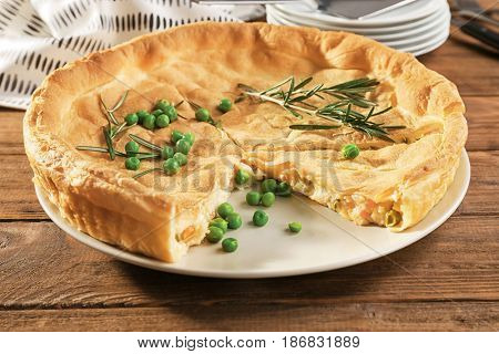 Tasty chicken pot pie with green peas on plate