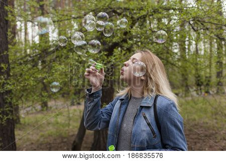 beautiful girl in spring blow bubbles in the Park area