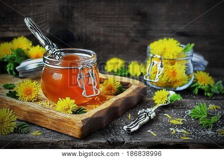 Dandelion jam in a jar and fresh flowers