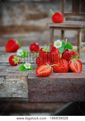 fresh strawberries and fresh flowers in the cottage, wooden background