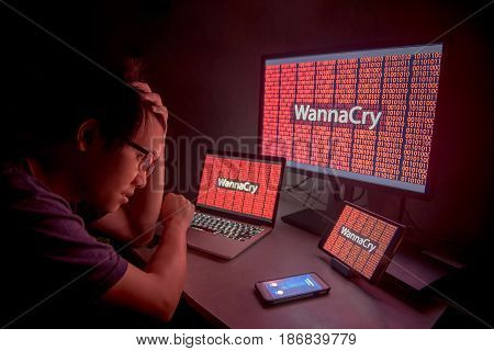 WannaCry ransomware attack on desktop screen notebook and smartphone internet cyber attack with Anonymous calling on smart phone to get the ransoms payment to decrypt the code