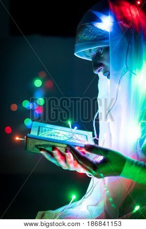Muslim woman praying in dark room with nice lights around her