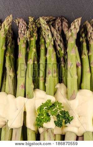 green asparagus on stonery background with sauce