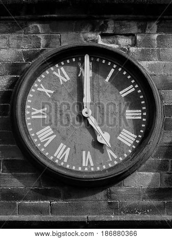 old clock face on stone wall with roman numerals