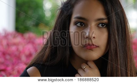 Serious Hispanic Teen Girl with Purple Flowers