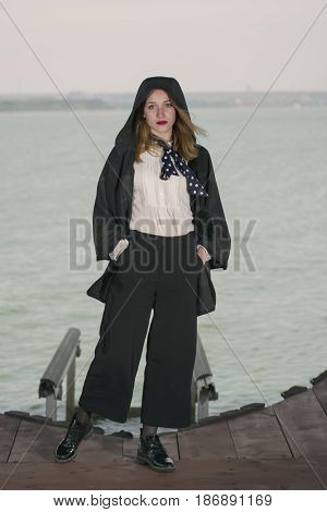 Young girl posing on pier at Lake Siutghiol