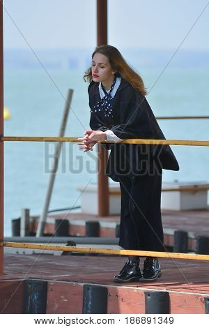 Young girl posing on pier at Lake Siutghiol