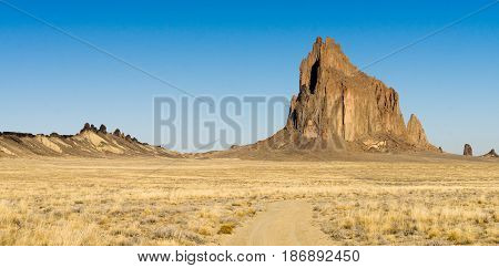 Blue skies appear in a panoramic view of Shiprock