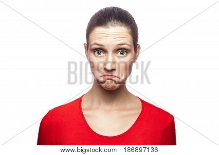 I don't know. portrait of funny confused woman in red t-shirt with freckles. looking at camera studio shot. isolated on white background.