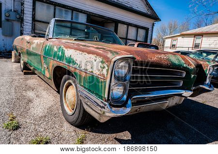 GOSHEN VIRGINIA- APRIL 8 2017: Old car rusting away in front of an abandoned repair shop.