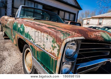 GOSHEN VIRGINIA- APRIL 8 2017: Old car rusting away in front of an abandoned repair shop.