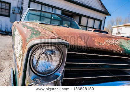 GOSHEN VIRGINIA- APRIL 8 2017: Old car rusting away in front of an abandoned repair shop.
