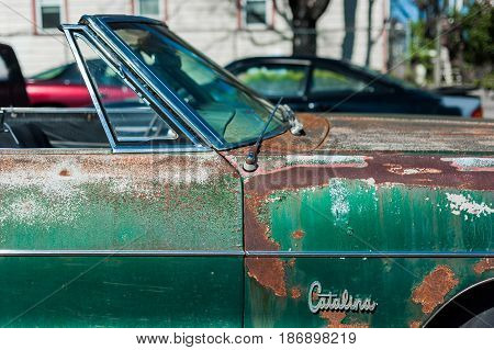 GOSHEN VIRGINIA- APRIL 8 2017: Old car rusting away in front of an abandoned repair shop.
