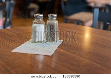 Salt and pepper shakers resting on top of the check