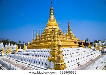 Golden Sandamuni Pagoda with row of white pagodas. Amazing architecture of Buddhist Temples at Mandalay. Myanmar (Burma) 