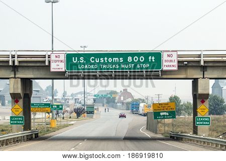 Sweet Grass Montana - Circa September 2015: Signs indicate that drivers are approaching the U.S. Customs area in Sweet Grass Montana near the Canadian border.