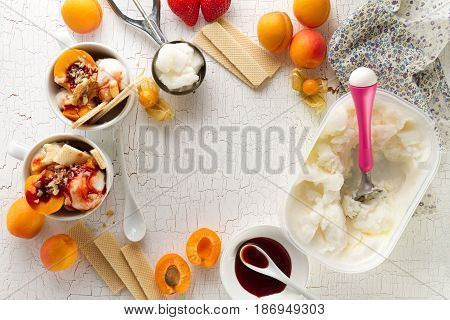 Tasty appetizing ingredients for cooking vanilla ice cream with ice cream spooons and fruits. Top View with Copy Space.