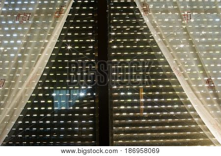 Window with lowered blind and curtains for background or textures