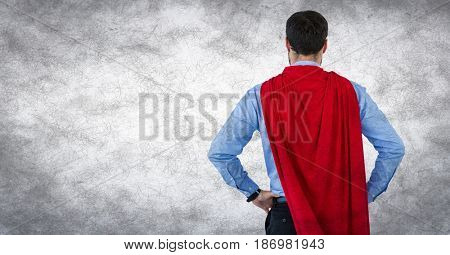 Digital composite of Back of business man superhero with hands on hips against white background and grunge overlay