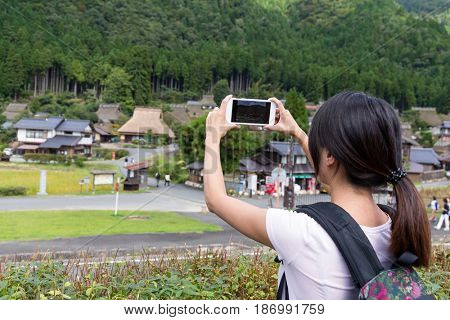 Woman taking photo in miyama of Japan