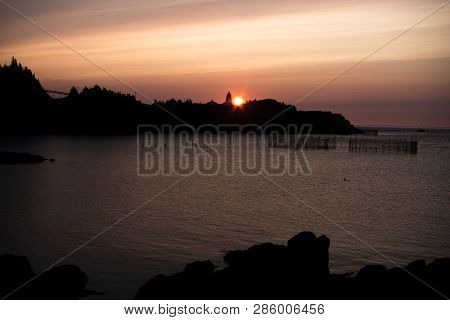 Sunrise Over Swallowtail Lighthouse On Granmd Manan With Seal In The Cove
