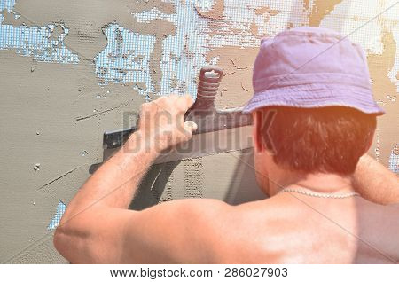 Fifty Years Old Manual Worker With Wall Plastering Tools Renovating House. Plasterer Renovating Wall