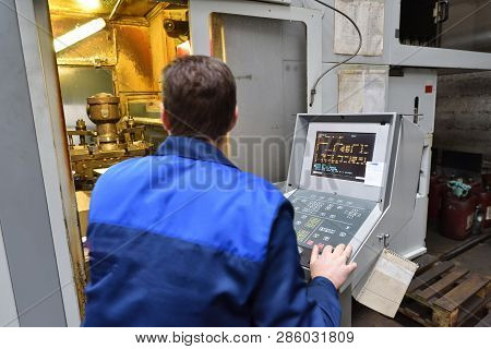 The Worker In Blue Workwear, The Operator Of The Cnc Machine, Oversees The Process And Controls It. 
