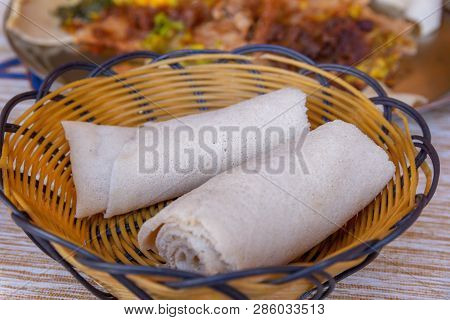 Rolls Of Injera In A Serving Bowl.  Injera Is A Sourdough Flatbread Made From Teff Flour.  It Is The