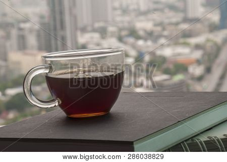 Hot Coffee Mugs Placed On A Notebook To Write A Diary In The Room Overlooking The City.