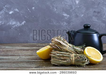 Organic Dry Lemongrass (cymbopogon Flexuosus) In Bunches And Lemon Fruit On A Wooden Table. Herbs Fo