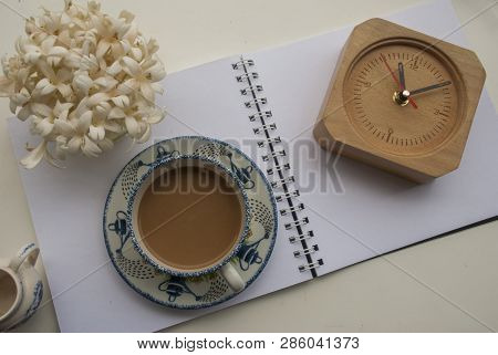 Flowers, Coffee And Notebooks And Watches On A White Wooden Table That Looks Relaxed