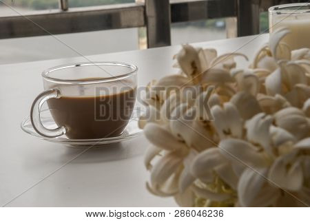 Coffee And Flowers On A White Table That Looks Relaxed