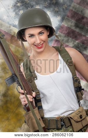 Pretty Young Woman Dressed In Wwii Military Uniform With A Helmet And Rifle