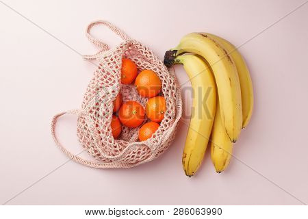 Fruits Tangerine, Banana In Recycling Net Market Bag On White Background. String Mesh Bag, Minial Co