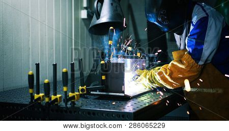 Worker Cutting Metalsheet By Acetylene Torch With Bright Sparks