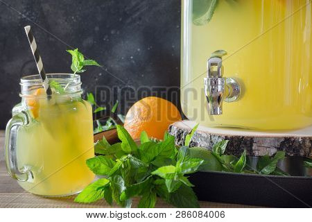 Lemonade With Orange, Citric , And Mint Cocktail In Mason Jar With Mint On Black Stone Table. Copy S