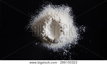 Easter Concept, Handrful Of Flour With Hole In The Center Shape Like Egg On Black Table. Preparation