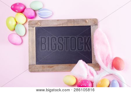 Easter Rabbit Flaffy Ears And Colored Easter Colored Eggs On Pink Background With Copy Space On Blac