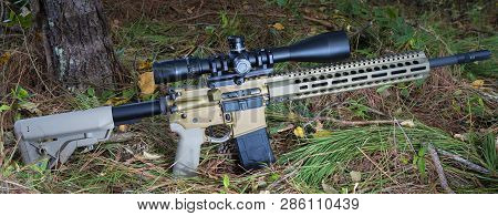 Ar-15 With Rifle Scope That Is On The Forest Floor