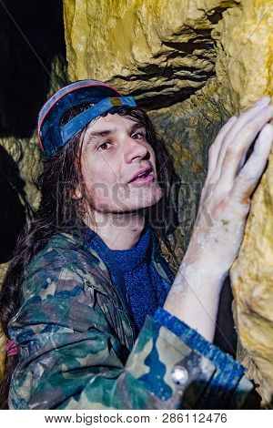 Man Explores Narrow Passage In The Cave